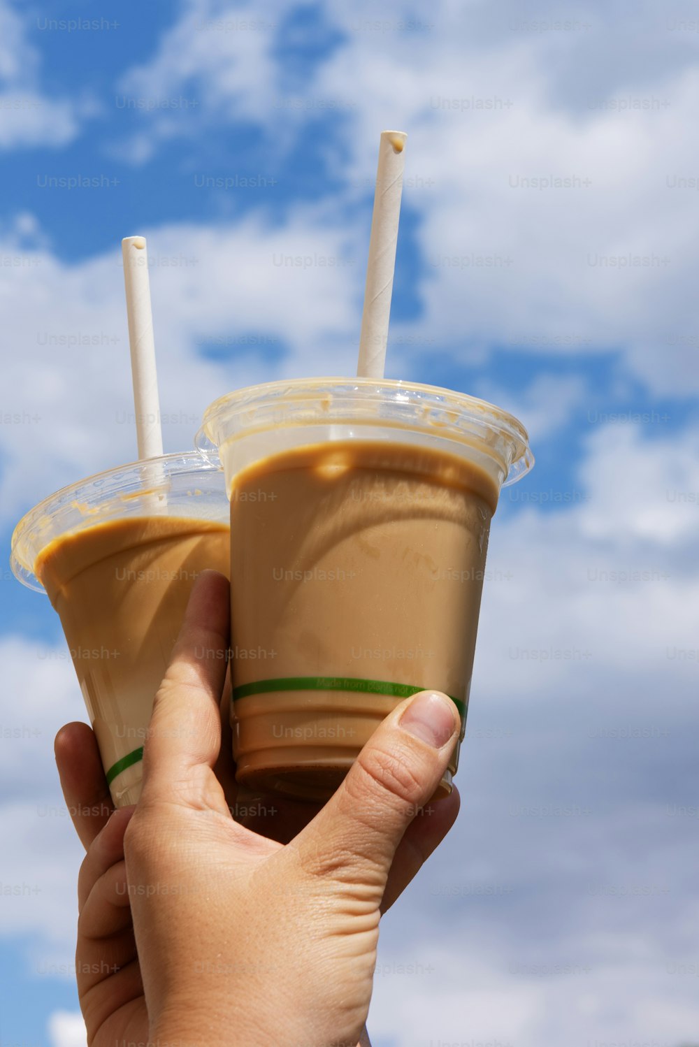 a hand holding a cup of iced coffee