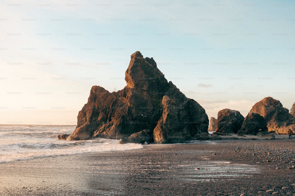 Una gran formación rocosa sentada en la cima de una playa de arena