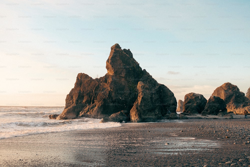 a large rock formation sitting on top of a sandy beach