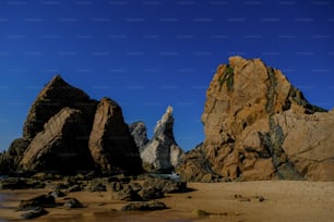some rocks on a beach with a blue sky in the background