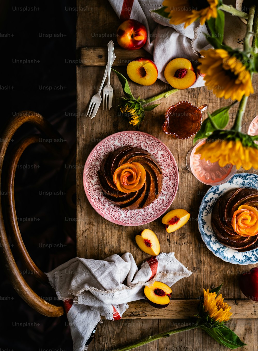 uma mesa de madeira coberta com pratos de comida e flores
