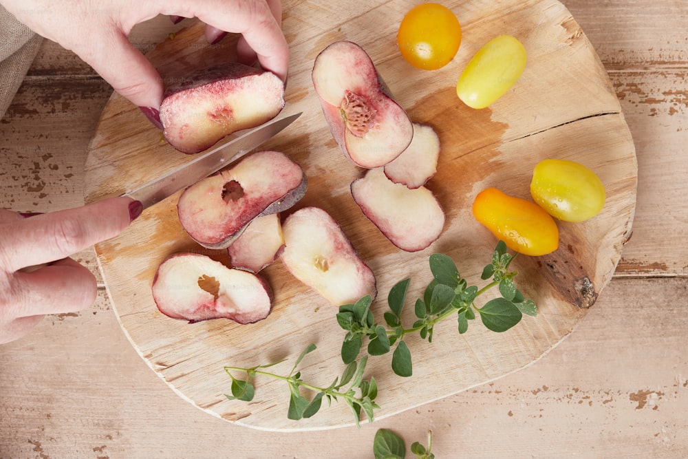 a person cutting up some fruit on a cutting board