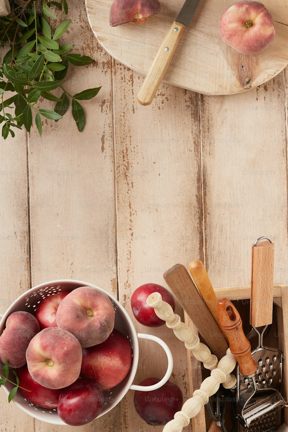 a bowl of peaches on a wooden table