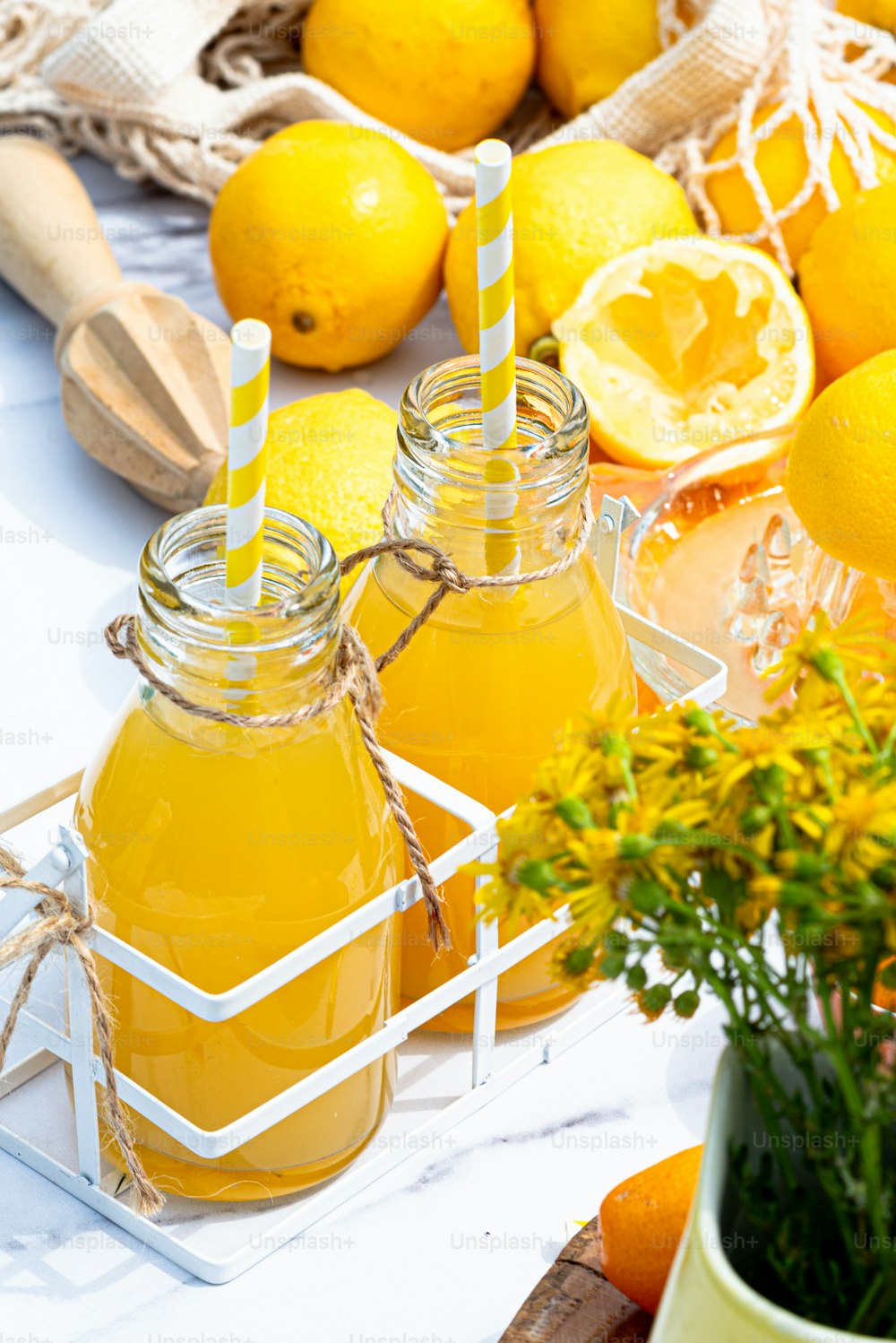 Una mesa cubierta con frascos de limonada y naranjas