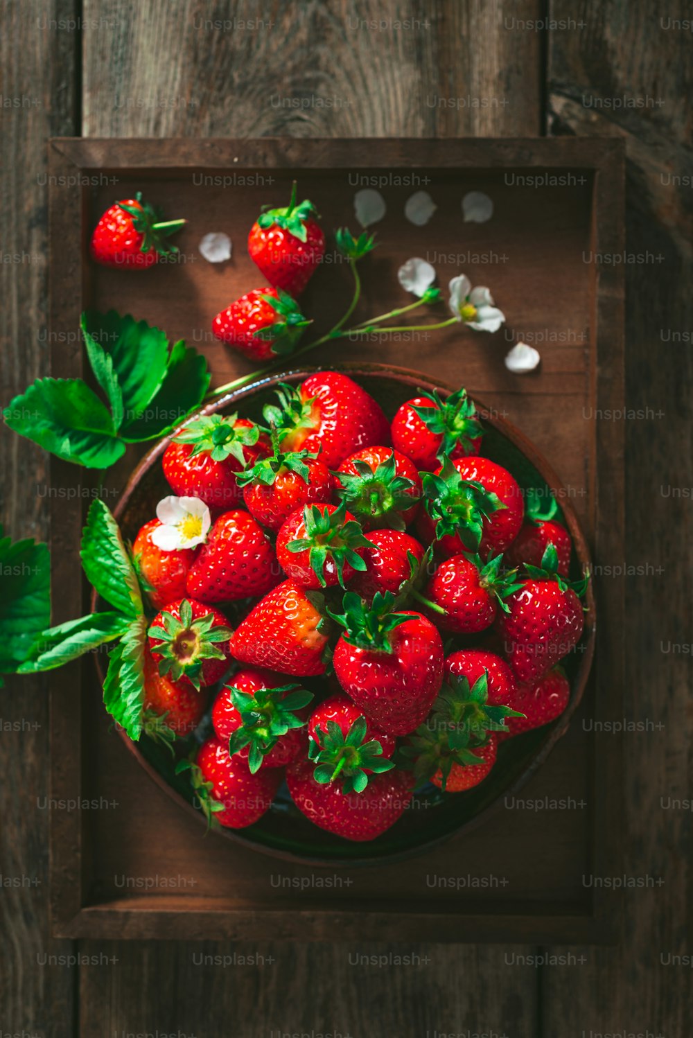 eine Schale Erdbeeren auf einem Holztisch
