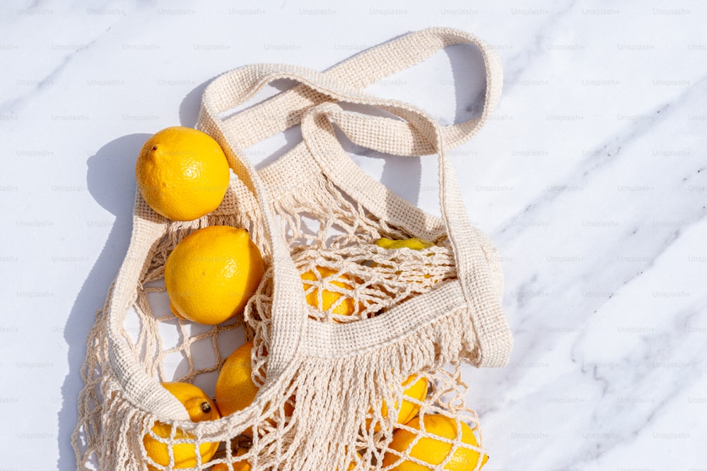 Una bolsa de limones encima de un mostrador blanco