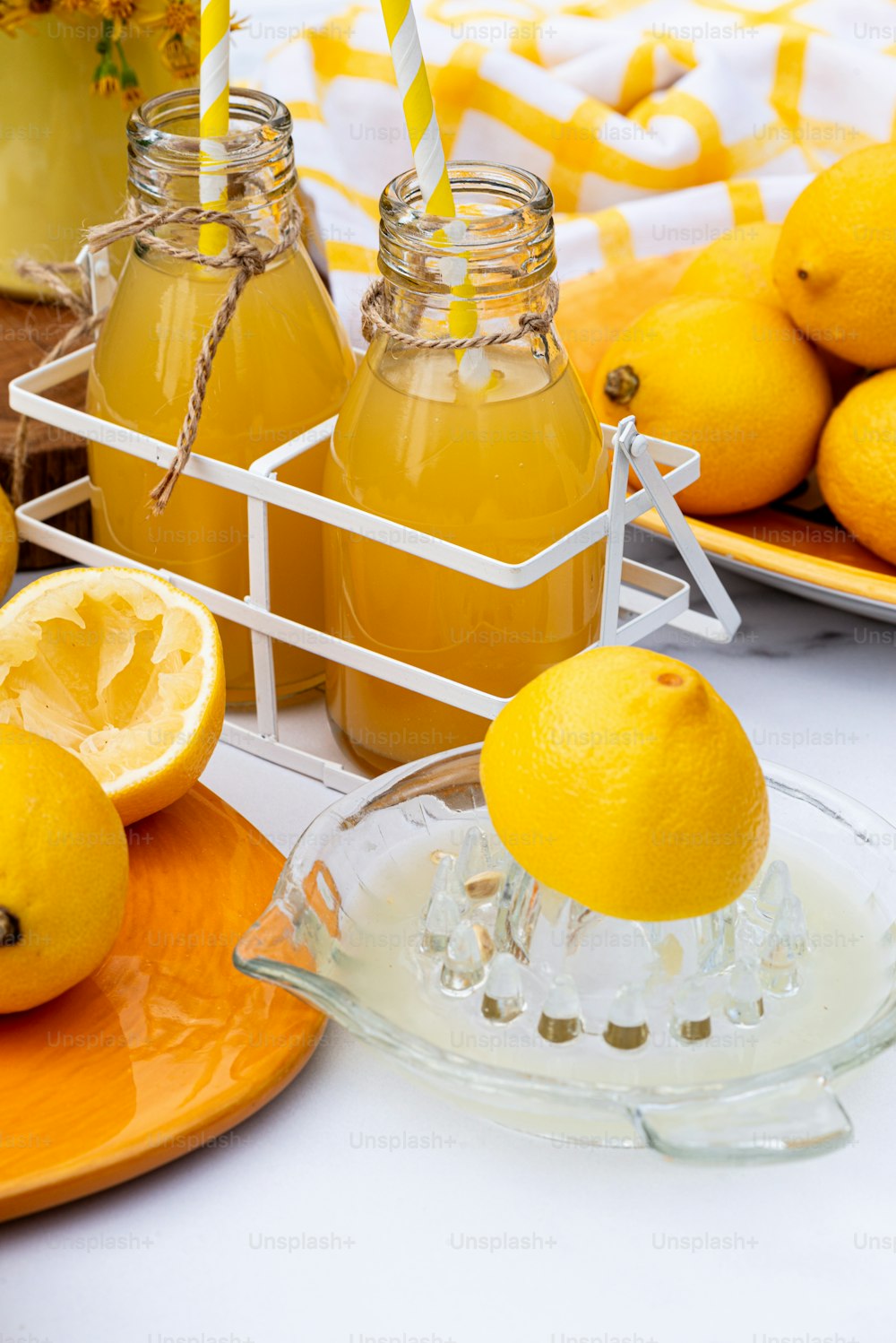 una mesa cubierta con naranjas y botellas de limonada