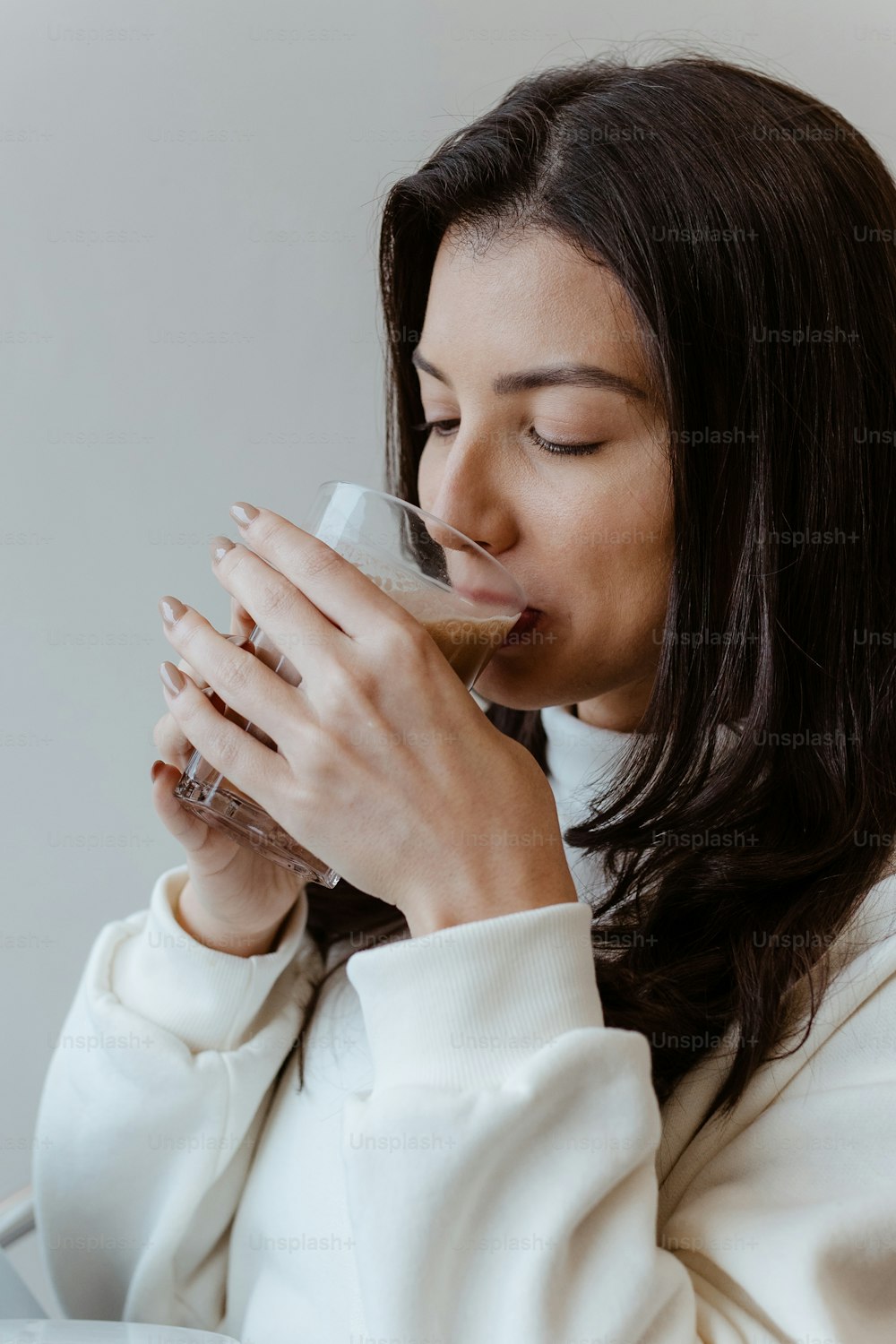 a woman drinking a glass of chocolate milk