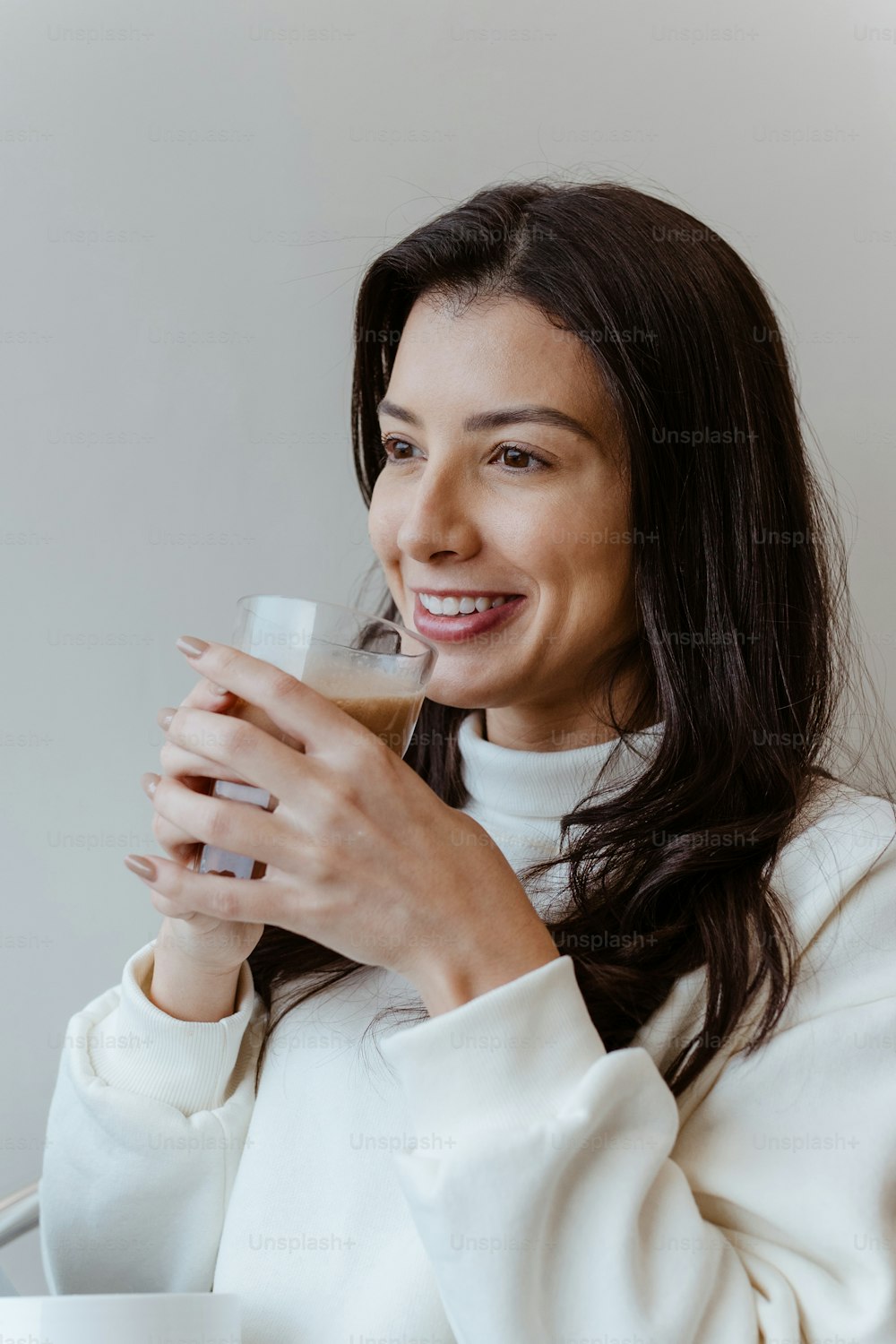 Una mujer sonriente sosteniendo un vaso de café