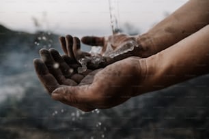 uma pessoa estendendo as mãos com água saindo delas