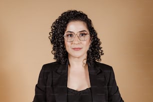 a woman wearing glasses and a black jacket