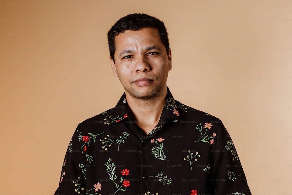 a man wearing a black shirt with red flowers on it