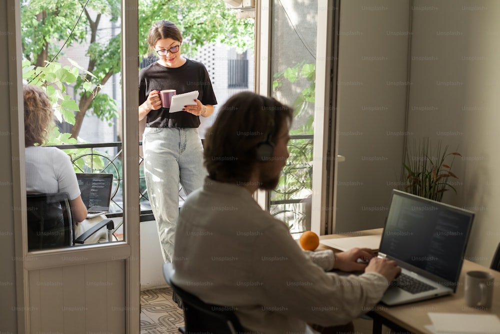 a woman sitting at a desk with a laptop computer