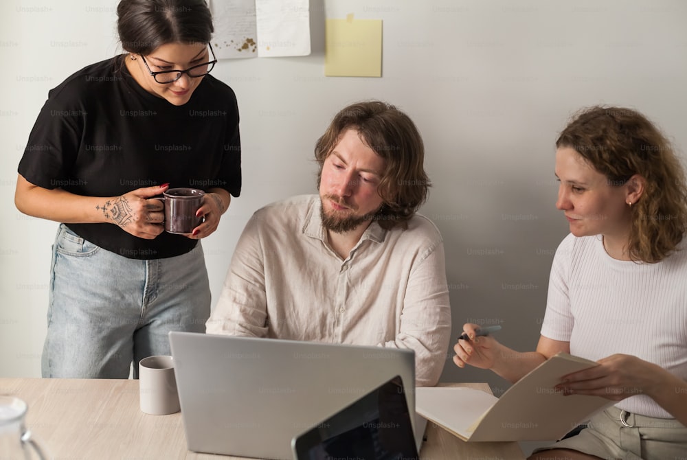 a man and a woman sitting at a table with a laptop