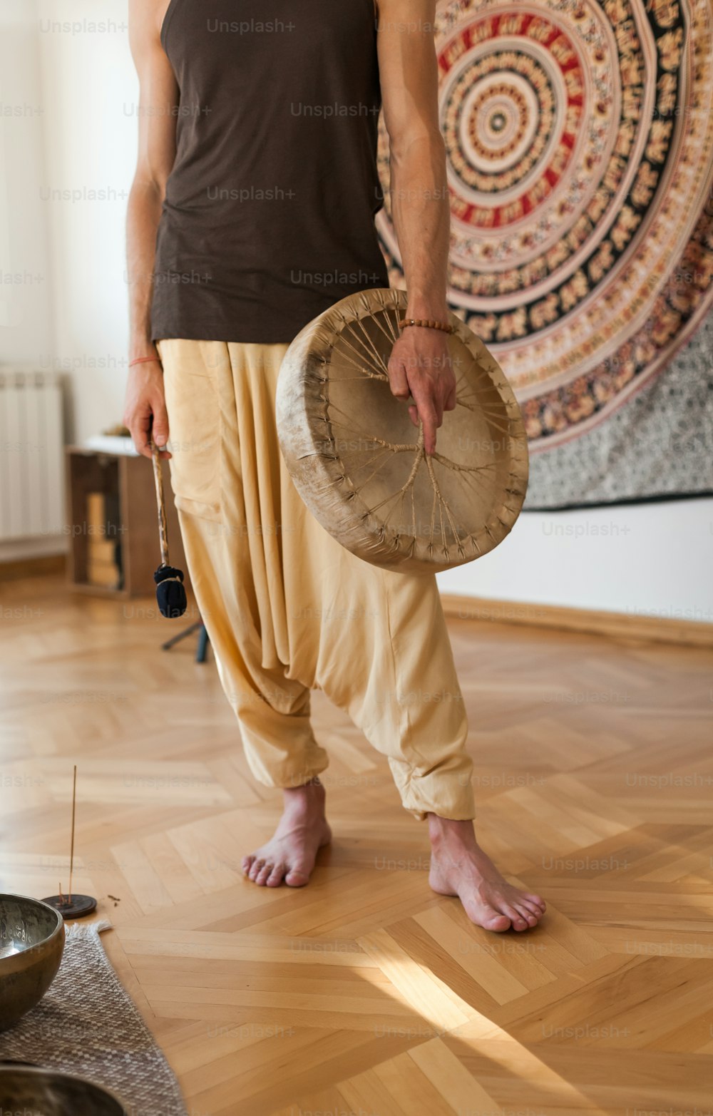a man standing in a room holding a drum