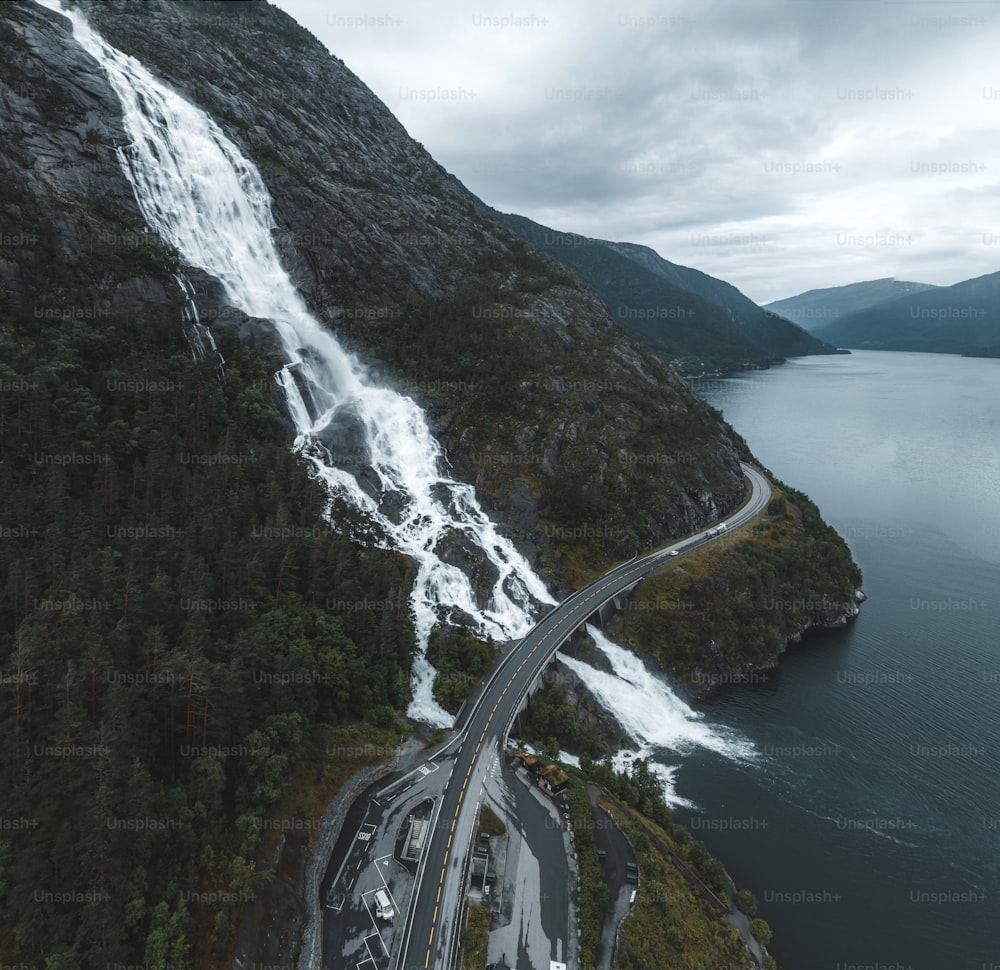 an aerial view of a highway near a waterfall