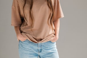 a woman wearing a tan shirt and blue jeans