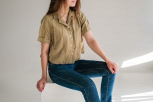 a woman sitting on top of a white box