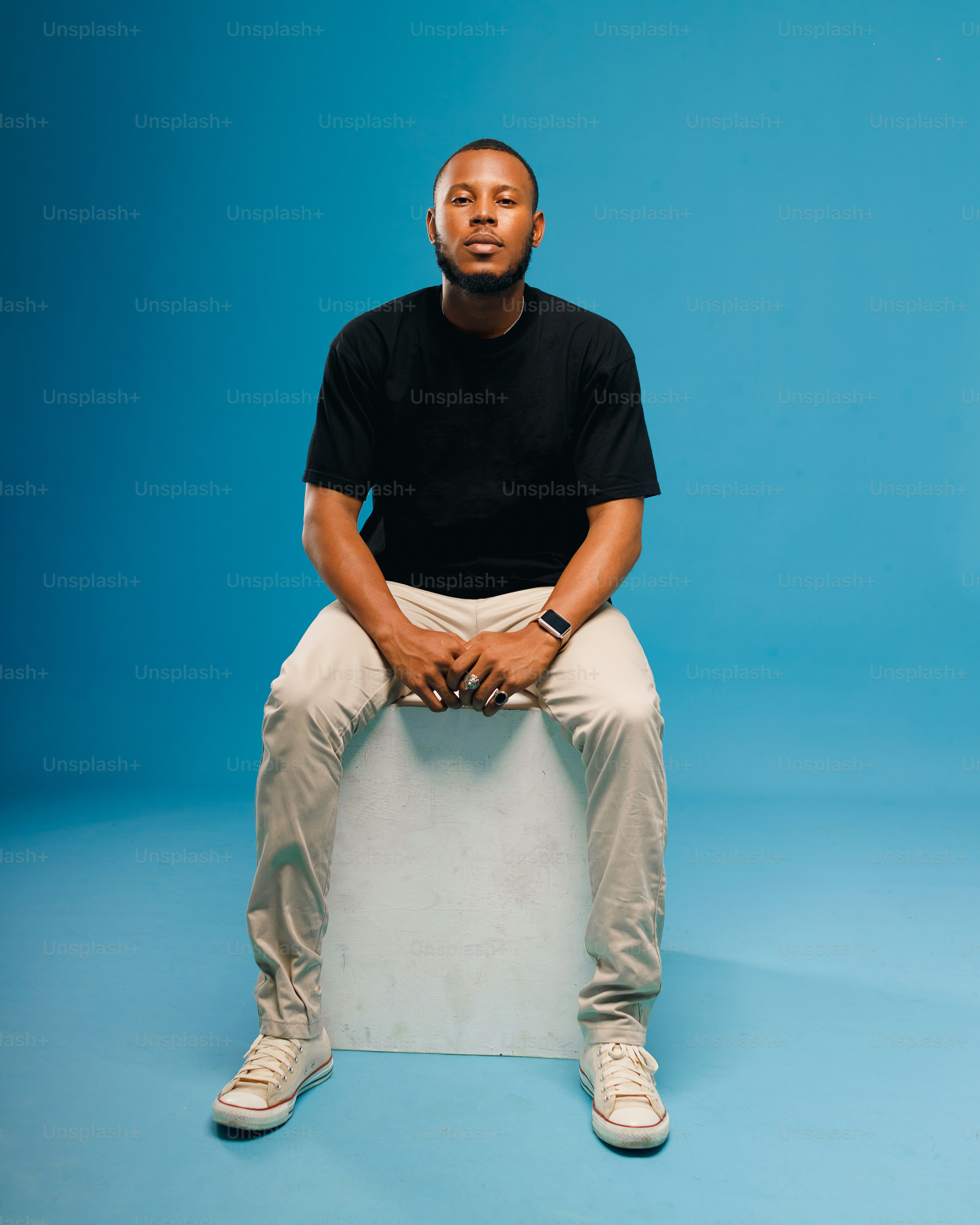 a man sitting on top of a white box