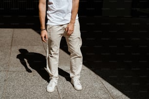 a man standing on a sidewalk with his hands in his pockets