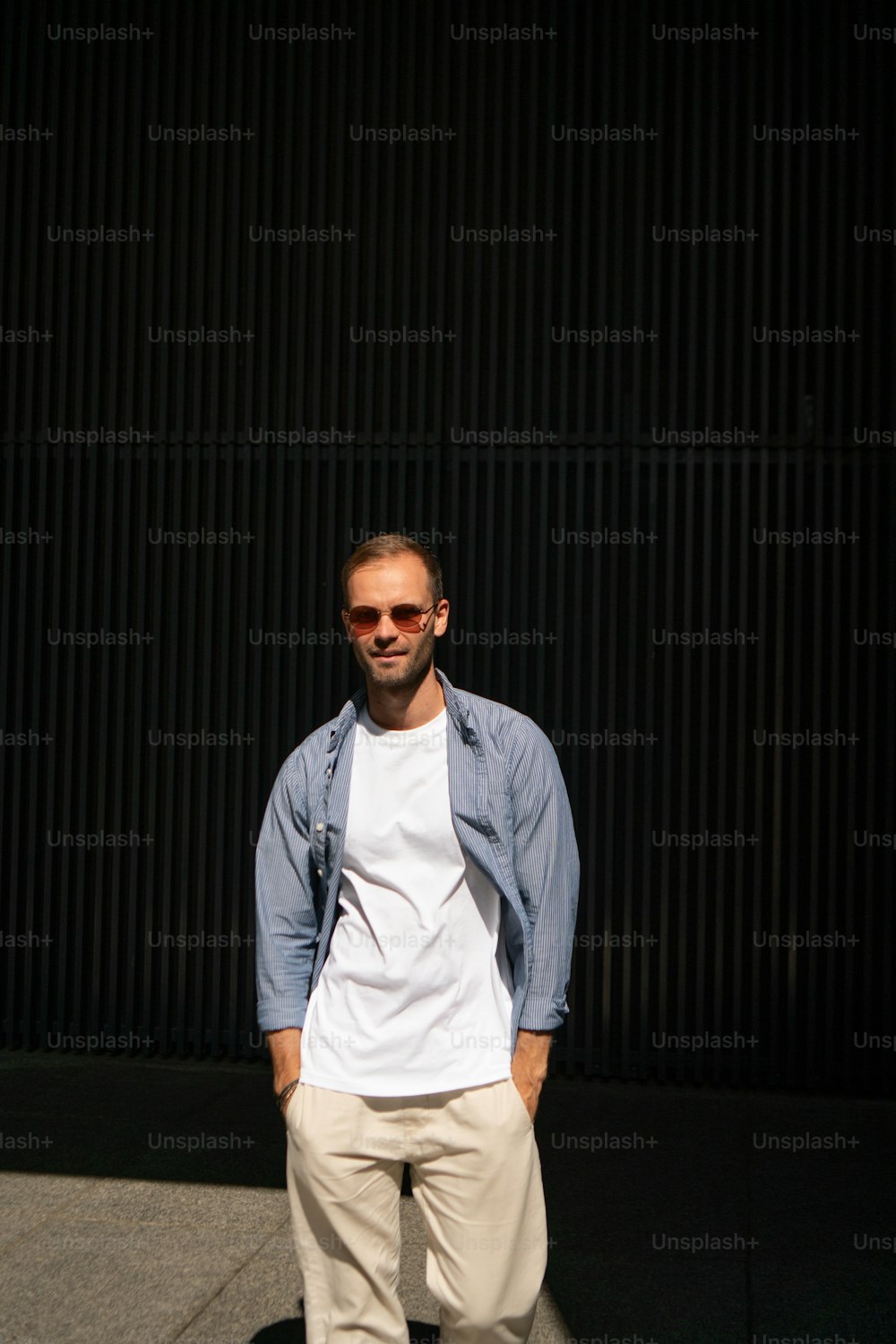 a man standing in front of a black wall