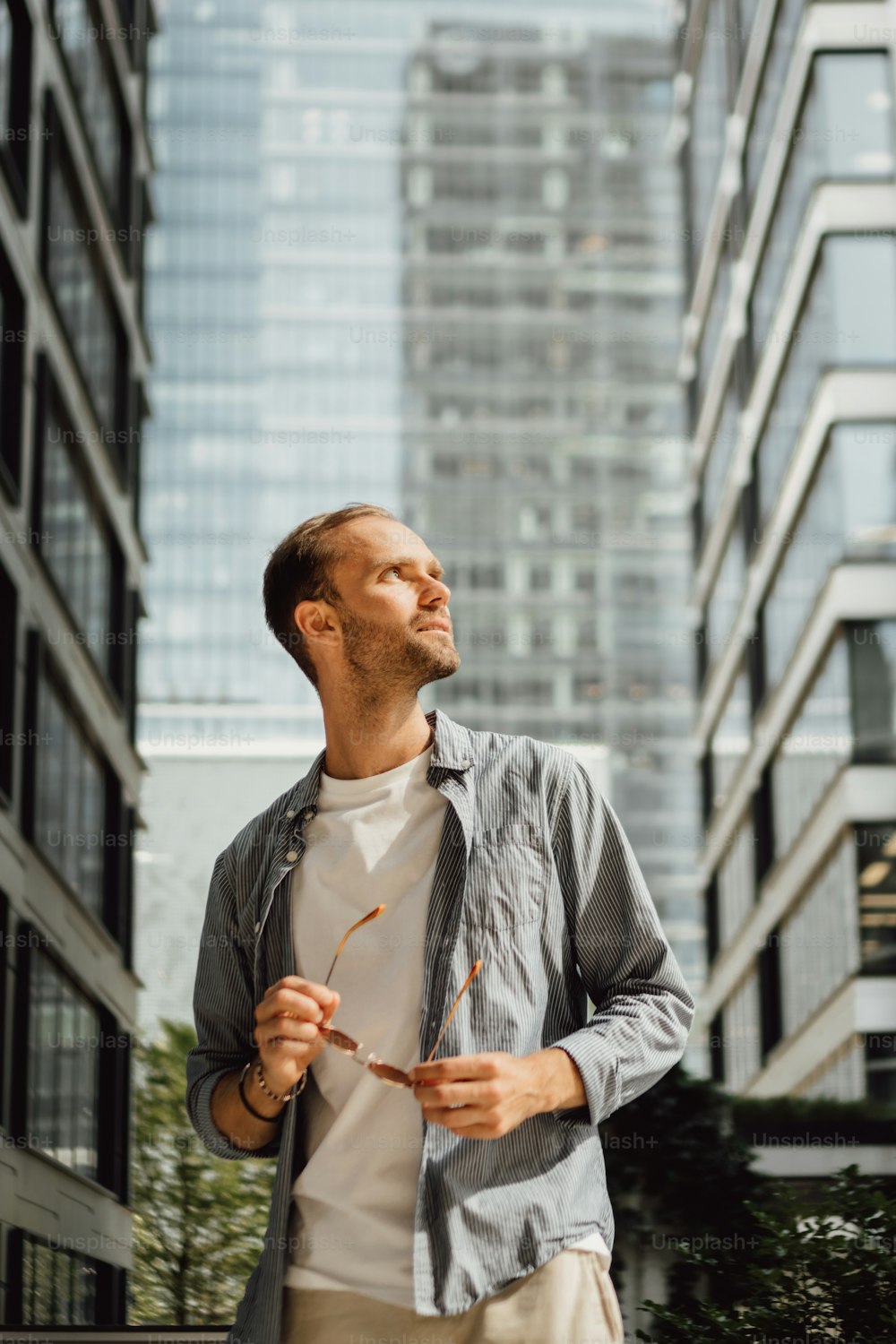 Un homme debout devant un grand immeuble