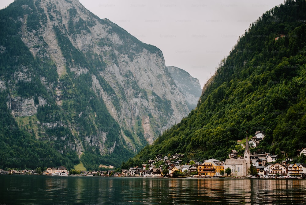 Un villaggio sulla riva di un lago con le montagne sullo sfondo