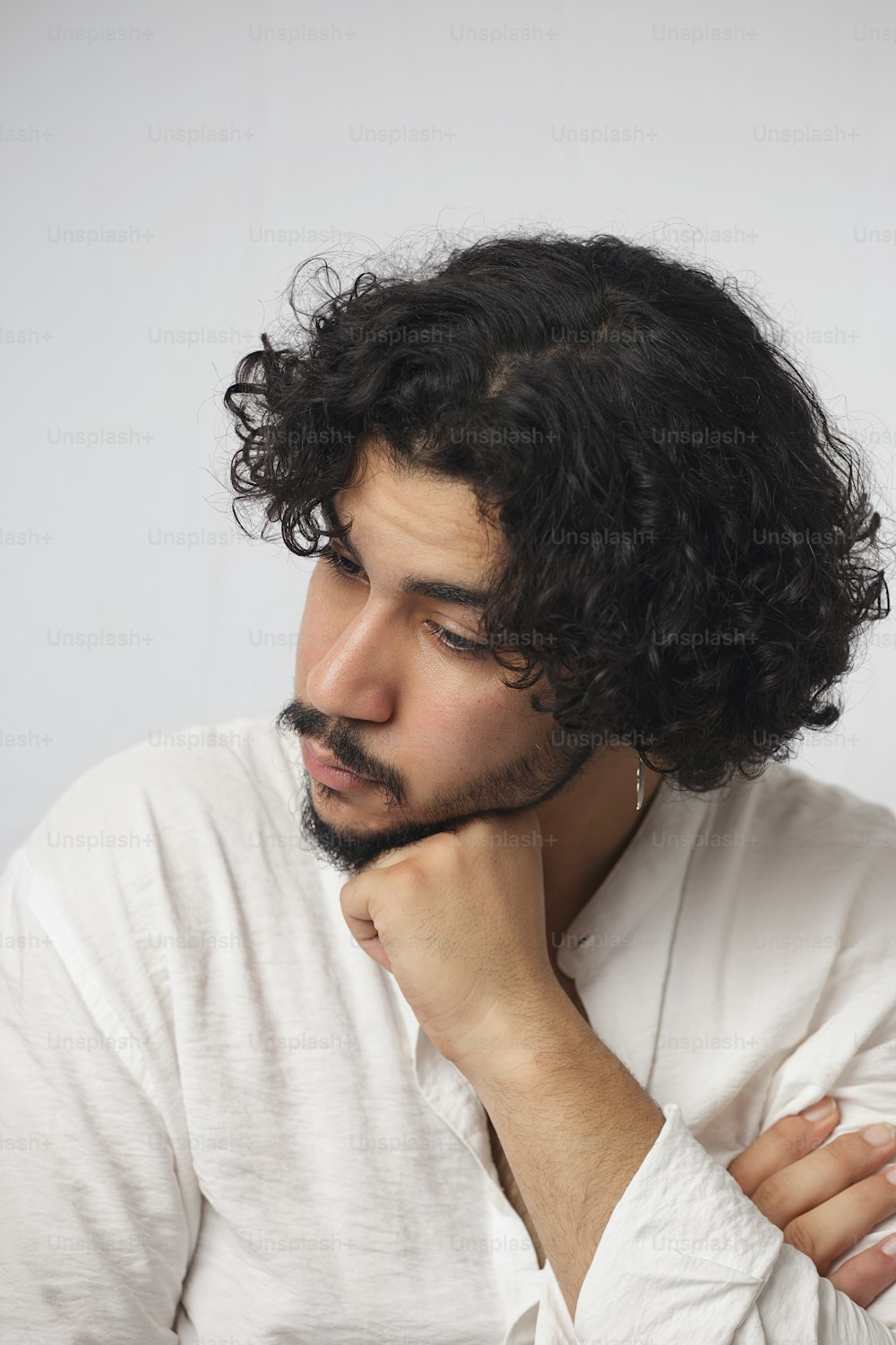 a man with curly hair wearing a white shirt