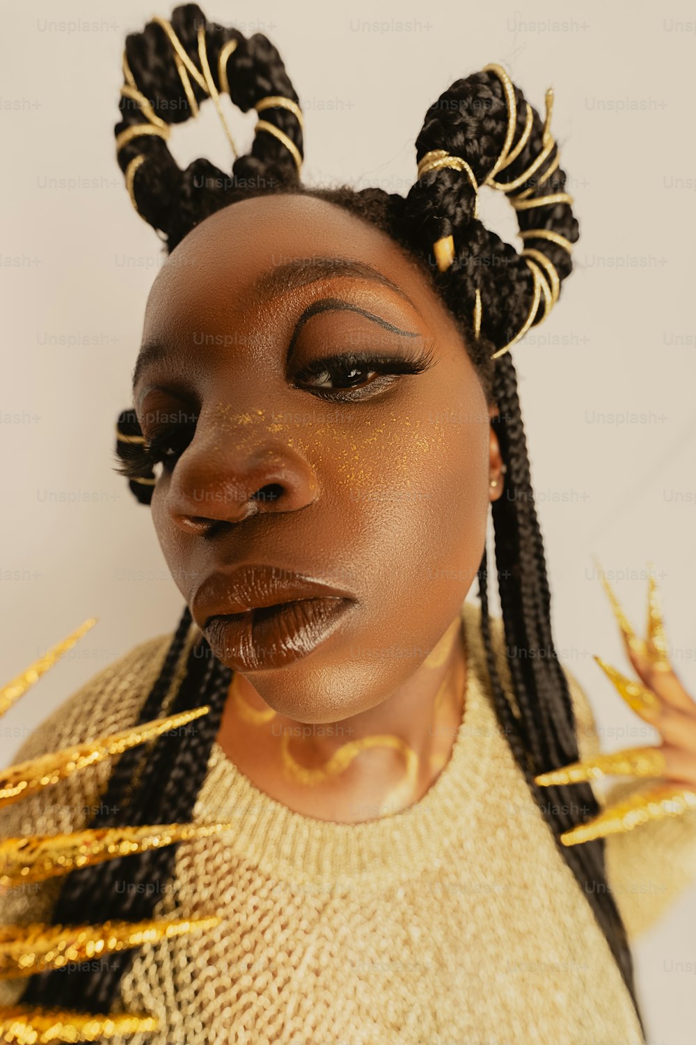 uma mulher negra com um top dourado e tranças na cabeça