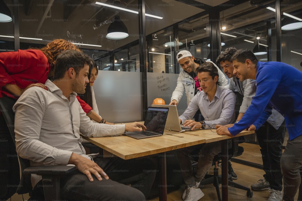 a group of people sitting around a wooden table