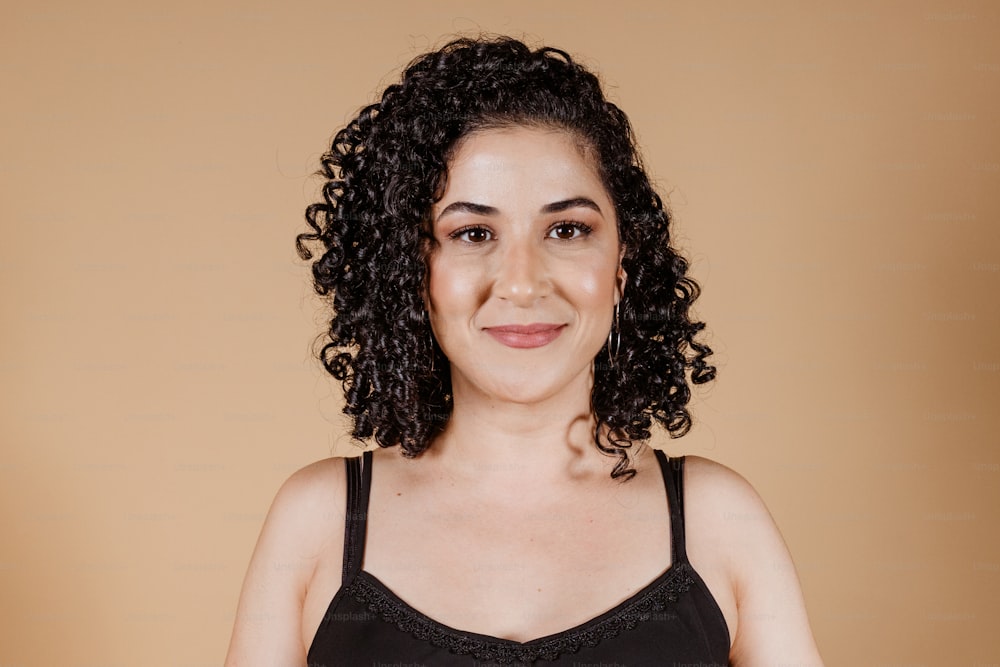 a woman with curly hair wearing a black top