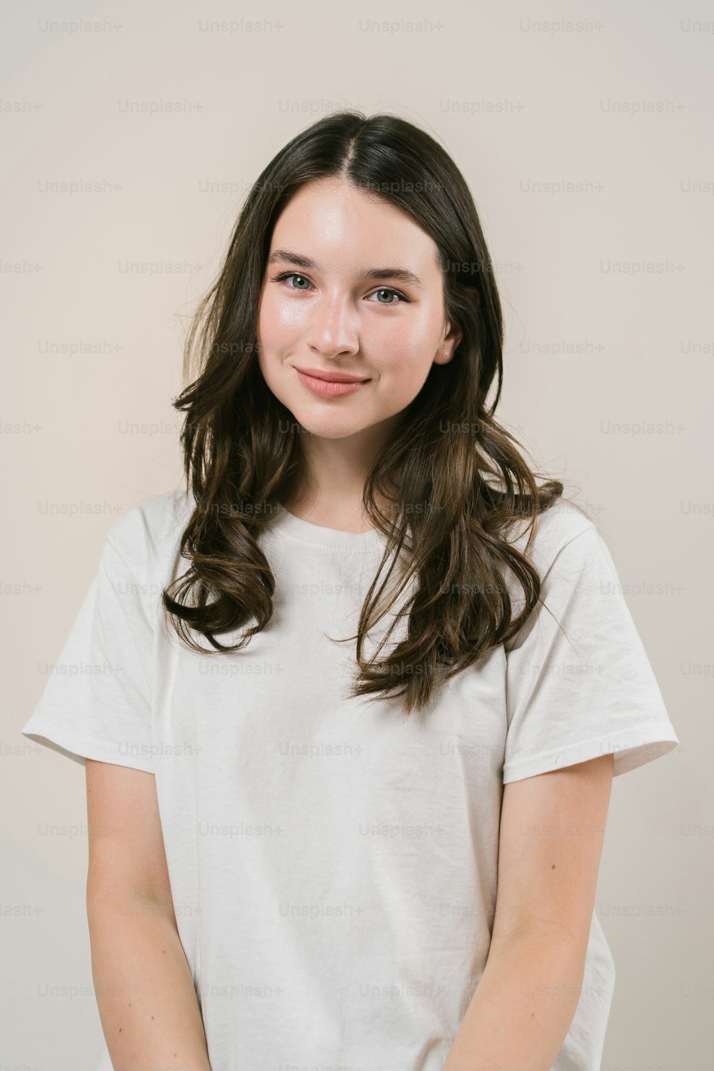 a young girl with long hair wearing a white t - shirt