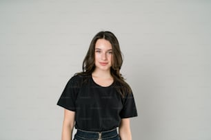 a woman standing in front of a white wall