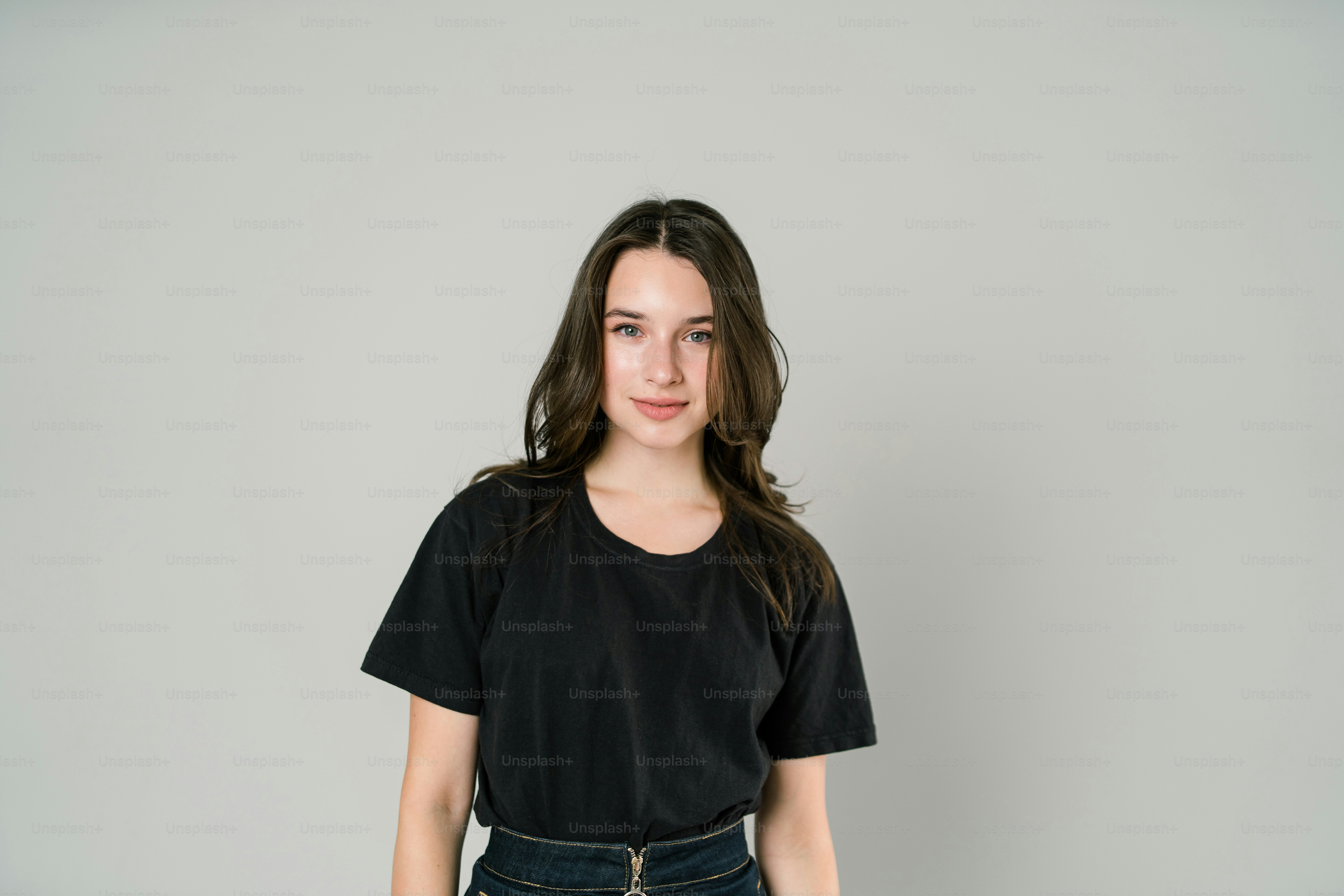 a woman standing in front of a white wall