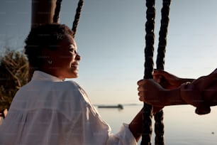 a woman in a white shirt holding onto a rope