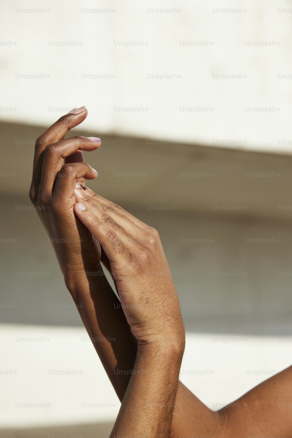 um close up das mãos de uma pessoa com um prédio ao fundo