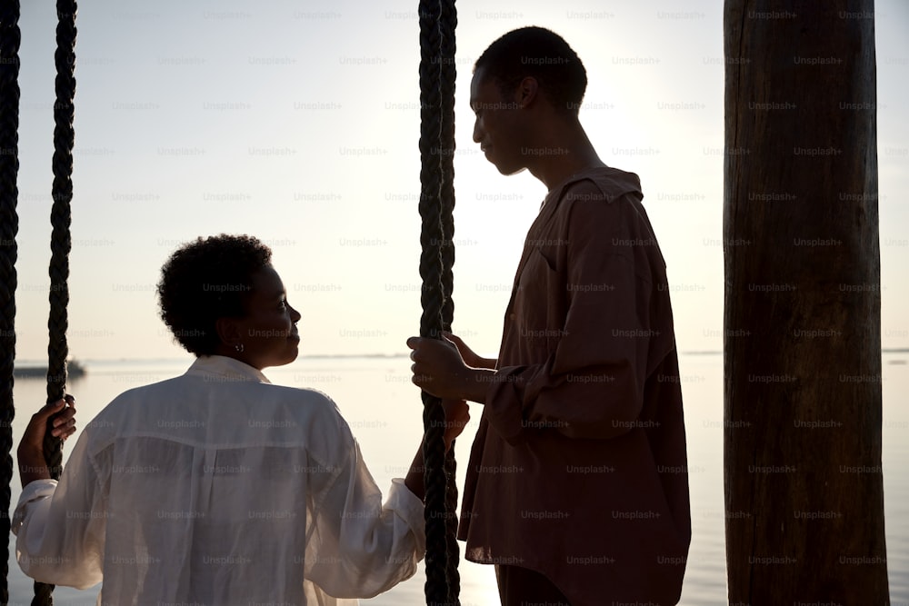 a man standing next to a woman on a boat