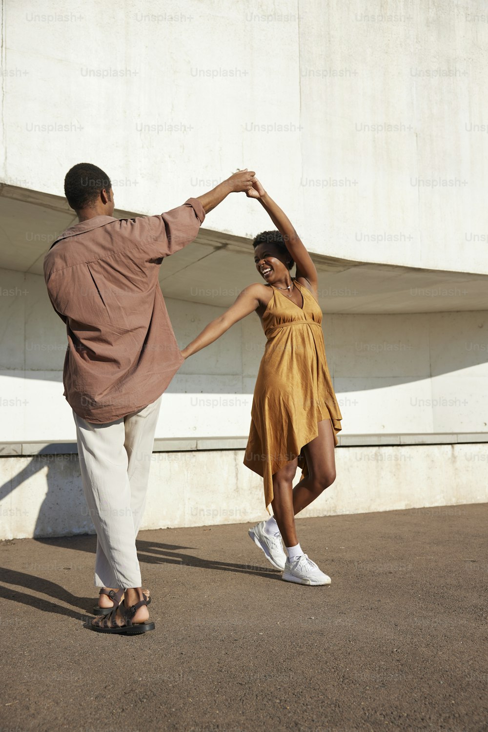 Un hombre y una mujer bailando juntos frente a un edificio