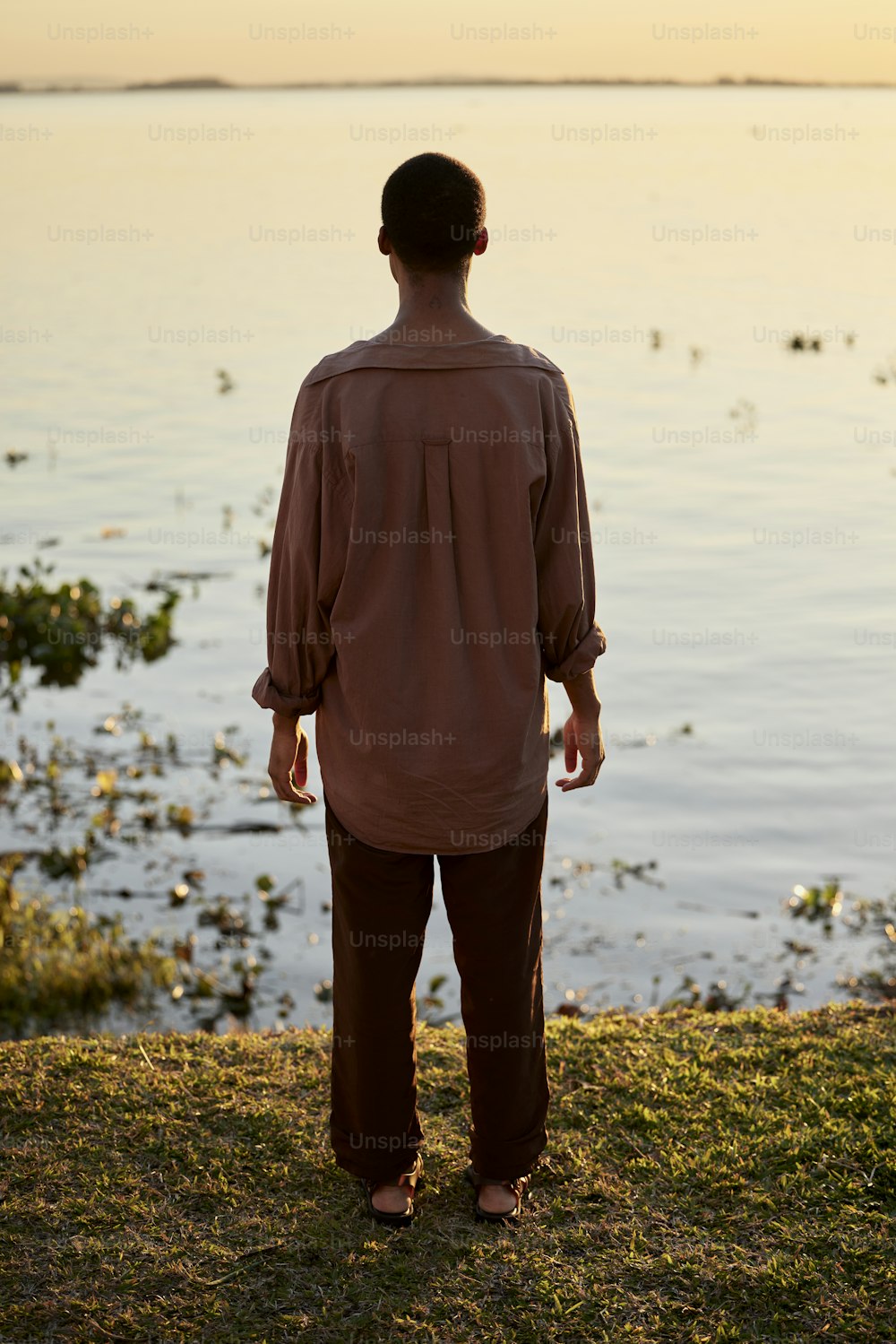 a man standing in front of a body of water