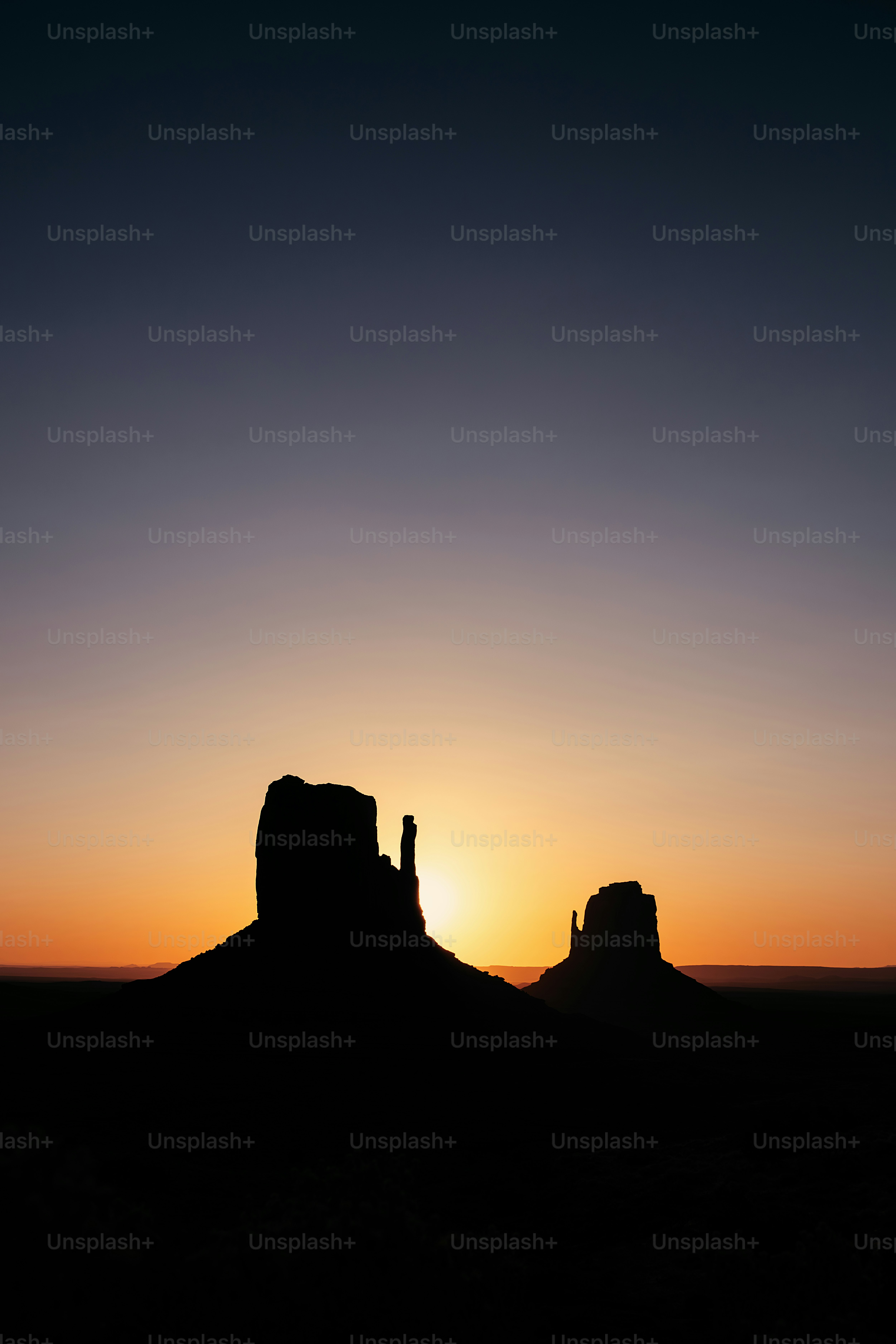 the sun is setting behind a rock formation