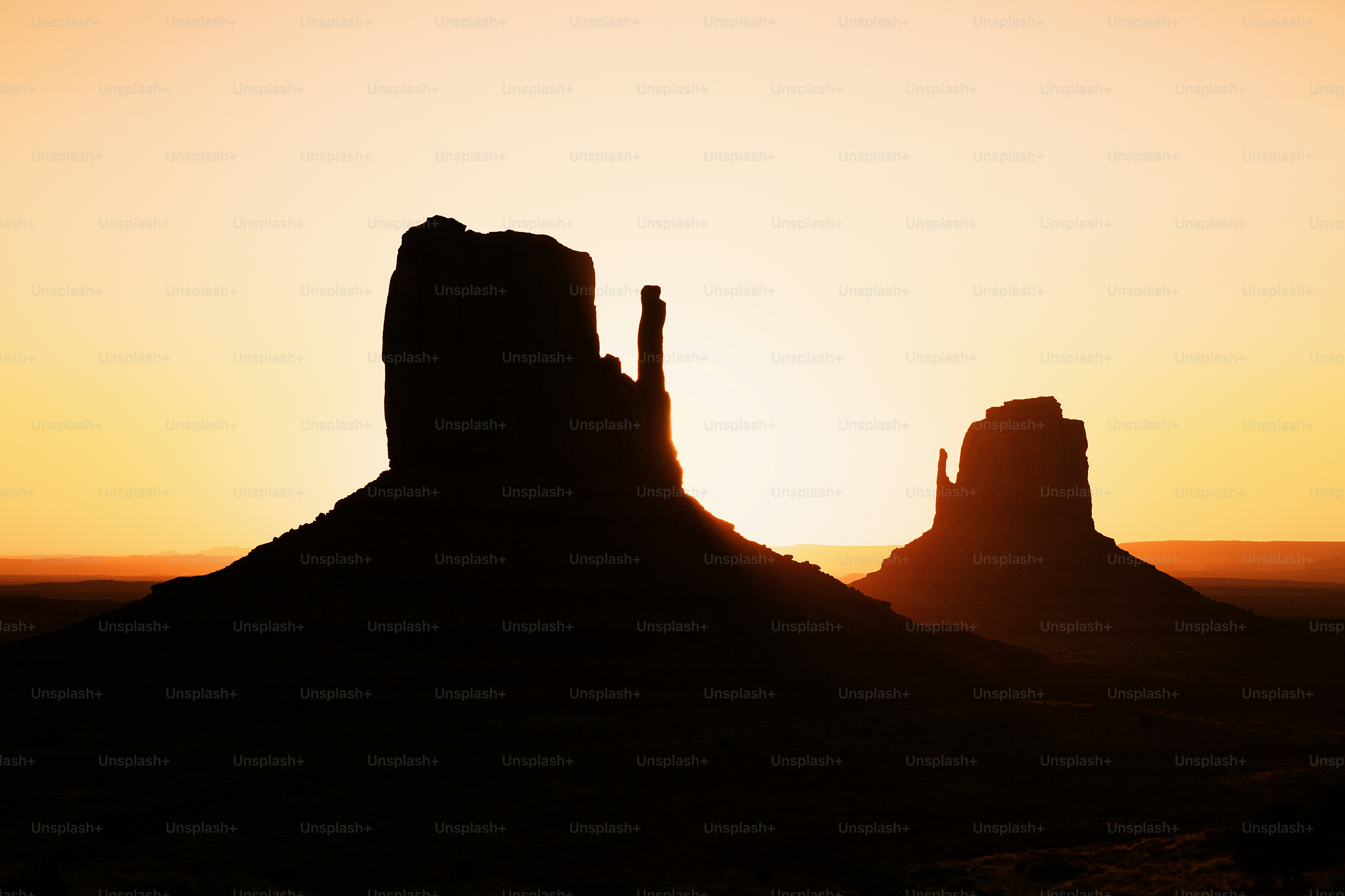 the sun is setting behind a large rock formation