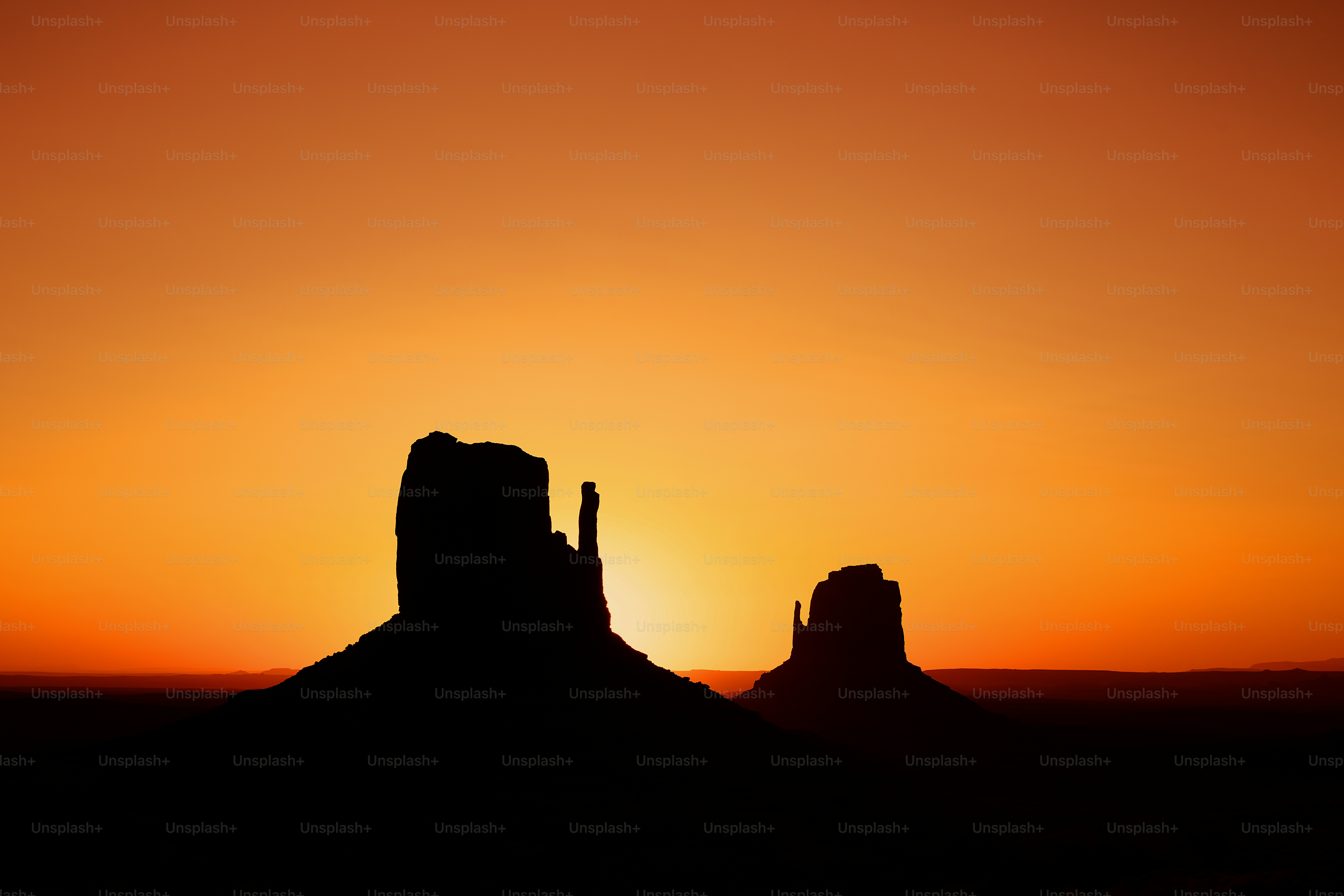 the sun is setting over a mountain in the desert