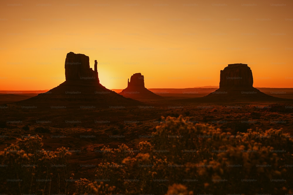 the sun is setting over the desert landscape