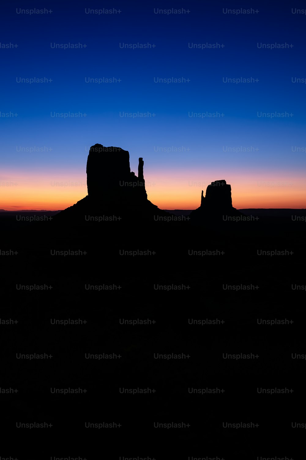 a silhouette of a rock formation at sunset