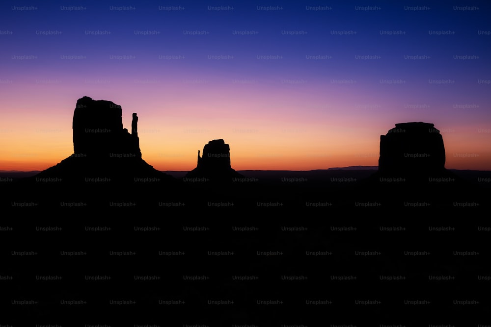 Blick auf eine Wüste bei Sonnenuntergang mit ein paar Felsen im Vordergrund