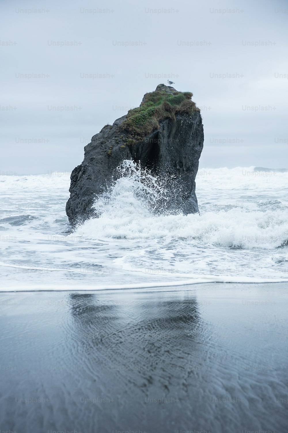 uma grande rocha saindo do oceano