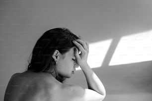 a woman in a black and white photo holding her head