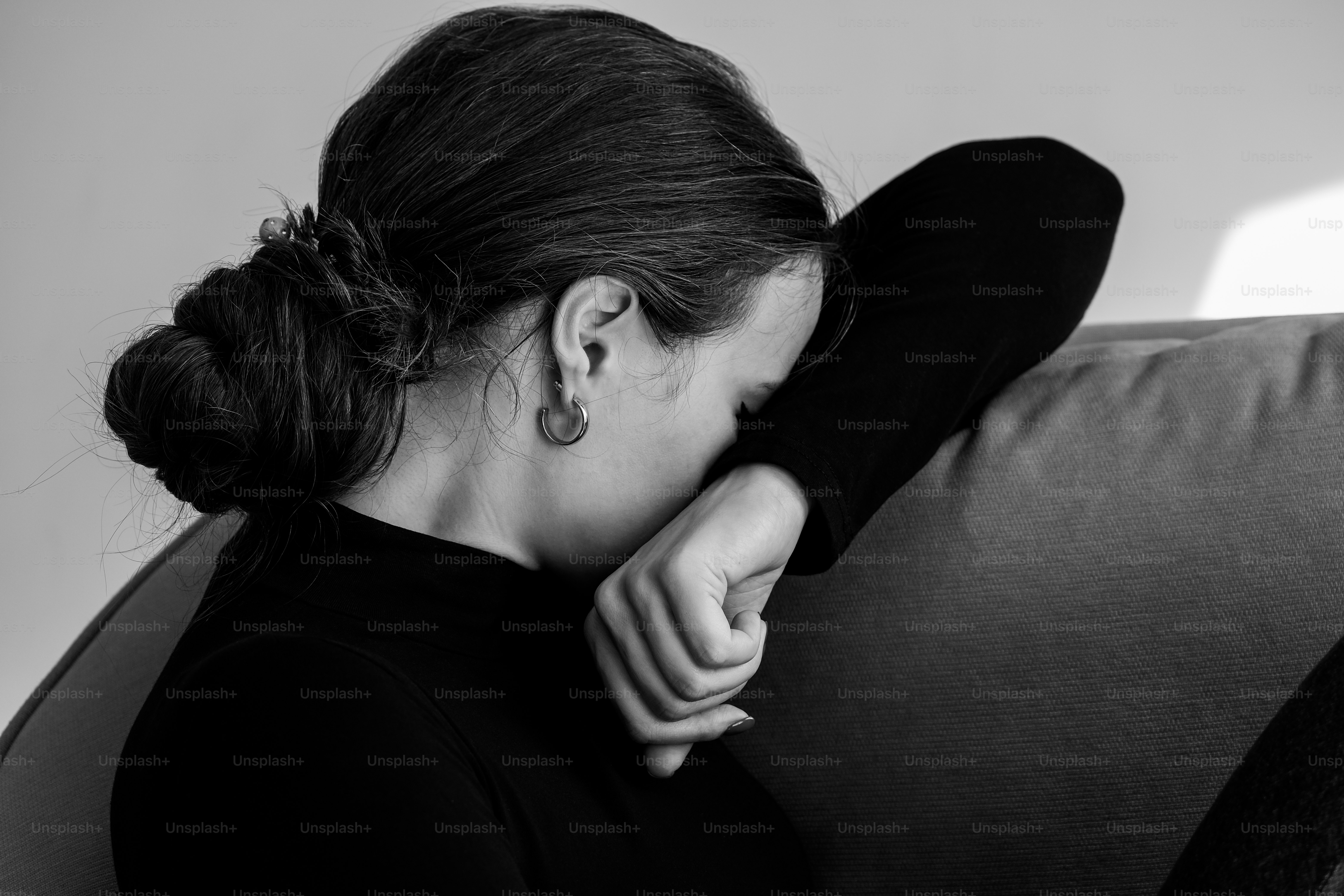 a black and white photo of a woman sitting on a couch