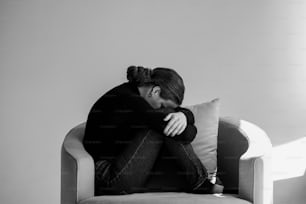 a black and white photo of a woman sitting on a couch