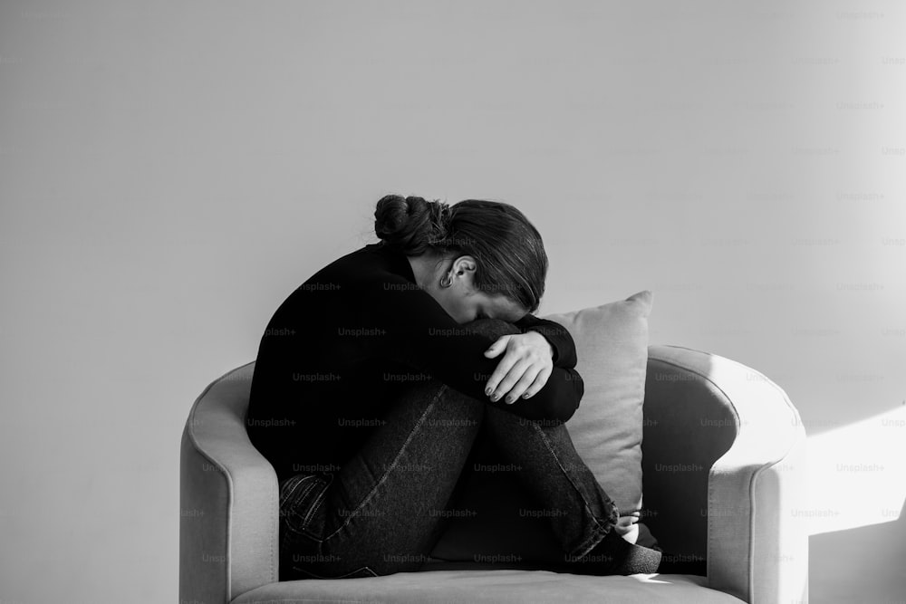 Una foto in bianco e nero di una donna seduta su un divano